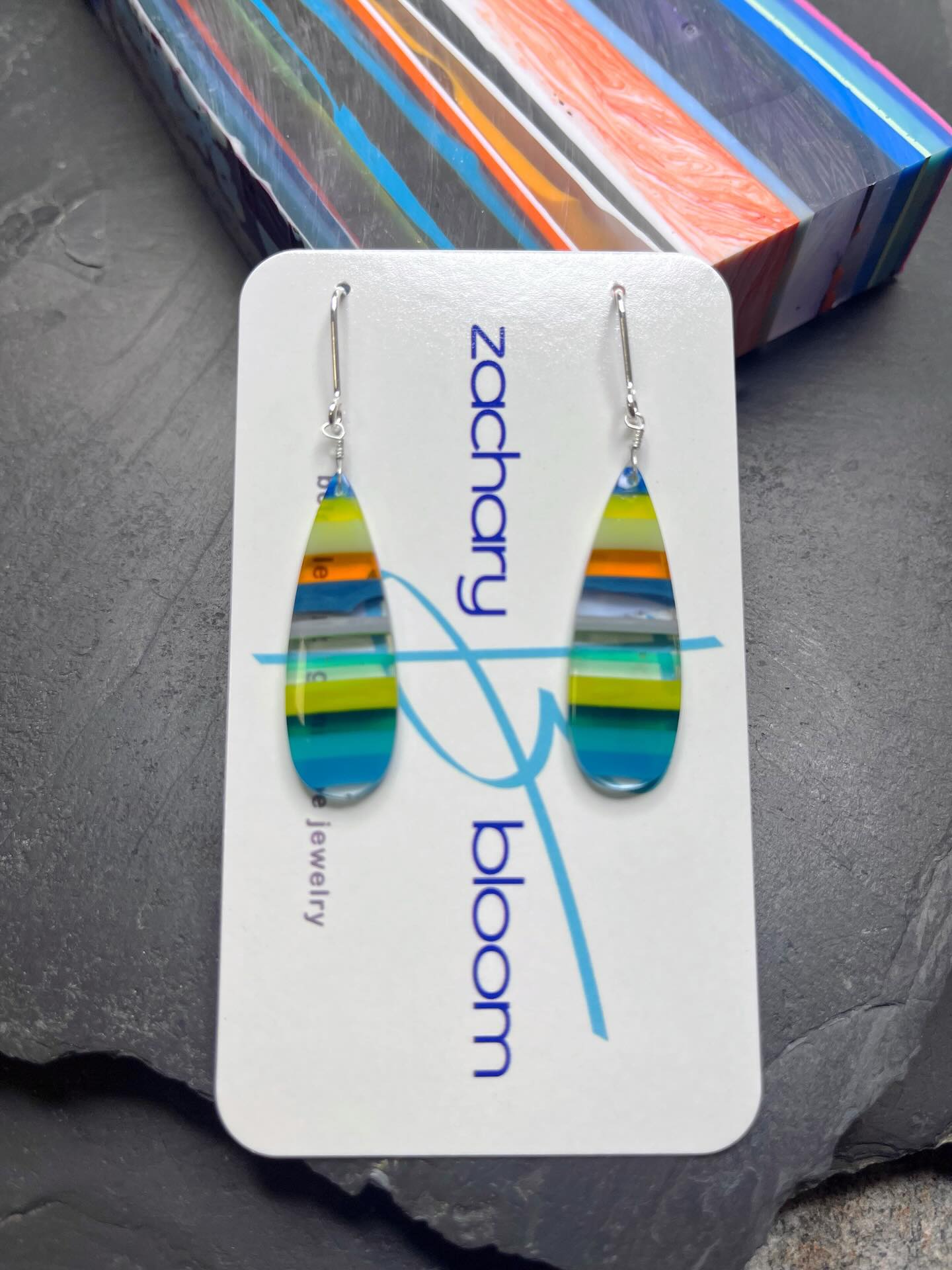 🏄‍♂️🏄‍♀️🏄
Gorgeous pair of hand-shaped SURFITE tear drop earrings right from the slab you see in the background. 
DM me for details on this pair of recycled surfboard resin.😜
#surfite #surfiteearrings #handshapedsurfboards #glassingsurfboards #zacharybloomjewelry